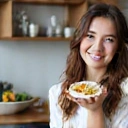 Smiling young woman, Emily White, looking healthy and happy, enjoying a balanced meal.